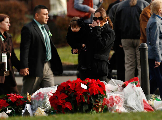 People walk past a memorial site following Jessica Rekos' funeral Mass at St. Rose of Lima Church in Newtown, Conn., Dec. 18. Photo: CNS.