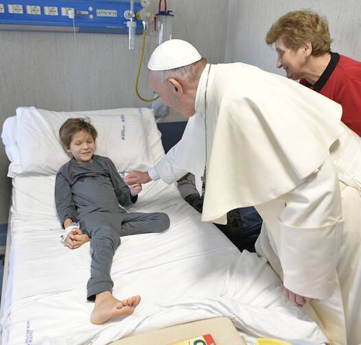 Pope Francis greets a patient during an unannounced visit Jan. 5 to children at the Palidoro Bambino Gesu Hospital, in Fiumicino, outside Rome. (CNS photo/L'Osservatore Romano)