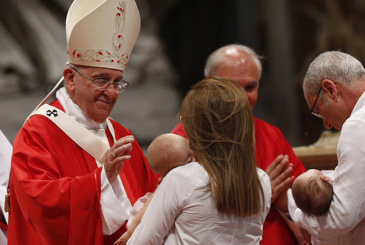 Pope Francis blesses babies as a couple present offertory gifts during the celebration of Mass marking the feast of Sts. Peter and Paul in St. Peter's Basilica at the Vatican June 29.
