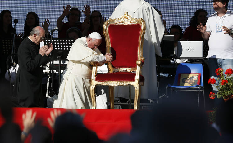 Pope Francis kneels as the crowd prays over him by singing and speaking in tongues during an encounter with more than 50,000 Catholic charismatics at the Olympic Stadium in Rome on June 1. 