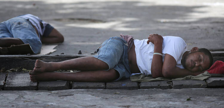 Men sleep on a sidewalk in Georgetown, Guyana, March 14. The World Bank and global faith leaders are joining together to end extreme poverty around the world by 2030. (CNS photo/Bob Roller)