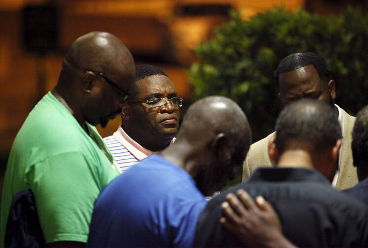 A small prayer circle forms nearby where police responded to a shooting at the Emanuel AME Church in Charleston, S.C., June 17. (CNS photo/Randall Hill, Reuters)