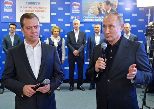 Russian President Vladimir Putin, right, and Russian Prime Minister Dmitry Medvedev, left, speak at United Party's election headquarters in Moscow, Russia, Sunday, Sept. 18, 2016.