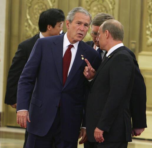 President George W. Bush speaks with Russian President Vladimir Putin in Beijing, August 2008.