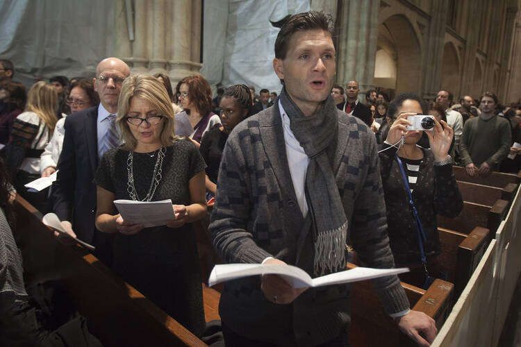 People sing carols during midnight Mass on Christmas at St. Patrick's Cathedral in New York (CNS photo/Carlo Allegri, Reuters).