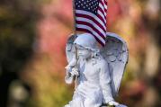 American flag sits on gravestone topped by angel figure at Wisconsin cemetery. (CNS photo/Sam Lucero, The Compass) 