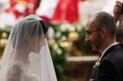 New spouses exchange rings as Pope Francis, pictured in the background, celebrates the marriage rite for 20 couples during a Mass in St. Peter's Basilica at the Vatican Sept. 14. (CNS photo/Paul Haring)