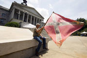 A man holds a Confederate flag outside the Statehouse in Columbia, S.C., on July 9, 2015, hours before Gov. Nikki Haley signed a bill to remove the flag from Statehouse grounds. (CNS photo/Jason Miczek, Reuters)