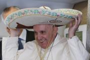 Pope Francis tries on a sombrero while meeting journalists aboard his flight to Havana on Feb. 12. (CNS photo/Paul Haring)