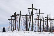 A woman prays on a hill with wooden crosses after a procession celebrating Palm Sunday in Oshmiany, Belarus, March 20. (CNS photo/Vasily Fedosenko, Reuters)