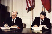 Soviet President Mikhail Gorbachev and U.S. President Ronald Reagan sign the Intermediate-Range Nuclear Forces treaty at the White House in Washington Dec. 8 1987. (CNS photo/Reuters)