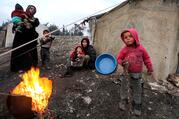 A file photo shows displaced Syrian women and children who fled from Idlib province gathering around a fire in Afrin. A majority of Syrians who have had to flee their homeland are Christians. (CNS photo/Khalil Ashawi, Reuters)