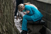 A health care worker in New York City rests on a bench near Central Park on March 30. (CNS photo/Jeenah Moon, Reuters)