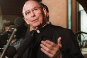 Cardinal Joseph Bernardin speaks with reporters on the steps of his Chicago residence just before his departure for Rome to meet with Pope John Paul II, Sept. 23, 1996.