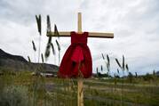 A child's red dress hangs on a cross near the grounds of the former Kamloops Indian Residential School in Kamloops, British Columbia.