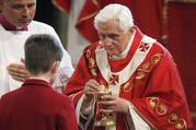 Pope Benedict XVI gives Communion to a young man during Mass at Westminster Cathedral in London.