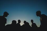 Silhouette photo of a group of people with a dark blue background