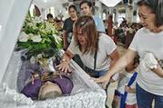 Mourners grieve by the casket of Father Richmond Nilo on June 11 n Zaragoza, Nueva Ecija, Philippines. Photo by Ezra Acayan.