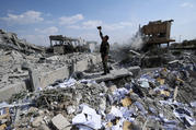 A Syrian soldier documents the damage to the Syrian Scientific Research Center from U.S., British and French military strikes on April 14. (AP Photo/Hassan Ammar)