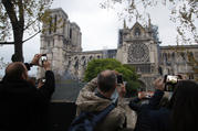 People take photos of the Notre Dame Cathedral in Paris, one day after a major blaze broke out at Paris' iconic cathedral. (AP Photo/Michel Euler, FILE)
