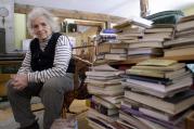 Grace Paley sits beside a pile of books in her home in Thetford Hill, Vt., April 9, 2003 (AP Photo/Toby Talbot).