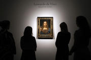 People gather around Leonardo da Vinci's 'Salvator Mundi' on display at Christie's auction rooms, in London, Tuesday, Oct. 24 (AP Photo/Kirsty Wigglesworth).