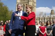Scotland's First Minister Nicola Sturgeon, with lawmaker Angus Robertson an SNP member of the UK Parliament, speak to the media outside the Palace of Westminster in London, Wednesday, April 19, 2017. British Prime Minister Theresa May on Tuesday called for a snap June 8 general election, seeking to strengthen her hand in European Union exit talks and tighten her grip on a fractious Conservative Party. (AP Photo/Alastair Grant)
