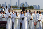 With the Chicago skyline in the background, deacons pray as participants gather to end violence and promote peace during the eighth annual Sunrise Prayer Service and Mass on Aug. 26, 2017. (CNS photo/Karen Callaway, Chicago Catholic)