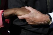 Members of the audience clasp hands during the dedication ceremony for the Rev. Martin Luther King Jr. Memorial in Washington in October 2011.