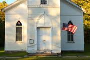 White country church and U.S. flag (iStock)