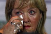 Woman who worked in a Magdalen laundries wipes tear during news conference in Dublin, Feb. 2013.