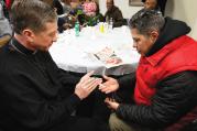 TURNING TOWARD MORNING. Archbishop Blase J. Cupich of Chicago blesses a rosary for Jaime Dones as he visited with patrons during a Thanksgiving dinner put on by Catholic Charities on Nov. 27, 2014. The dinner is held for the homeless and the hungry. 