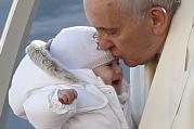 Pope Francis kisses a baby during his general audience in St. Peter's Square at the Vatican Dec. 10. (CNS photo/Paul Haring)