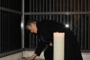 In this Dec. 10, 2009 file photo, Elie Wiesel lights a candle for Holocaust victims on a memorial wall, which identifies tens of thousands of Hungarian Holocaust victims, in the Holocaust Memorial Center in Budapest, Hungary (AP Photo/Bela Szandelszky).