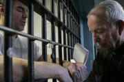 Priest prays with death-row inmate.