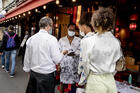 Women show their health passes to a waiter in Paris on Aug. 19, 2021. France, Italy, Denmark and the U.S. cities of New York, San Francisco and New Orleans are among the places that have imposed vaccination requirements at places like restaurants, gyms and theaters as the Delta variant of Covid-19 spreads. (AP Photo/Adrienne Surprenant)