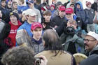 On Jan. 18, a teenager wearing a "Make America Great Again" hat, center left, stands in front of an elderly Native American singing and playing a drum in Washington. (Survival Media Agency via AP)