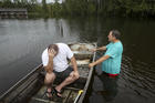 Stephen Gilbert, left, and his father-in-law sit in front of their flooded property on Sept. 20 in the Mauriceville, Texas, area. Floodwaters are starting to recede in most of the Houston area after the remnants of Tropical Storm Imelda flooded parts of Texas. Imelda will likely be Southeast Texas’ fifth 500-year flood event in as many years. ( Jon Shapley/Houston Chronicle via AP)