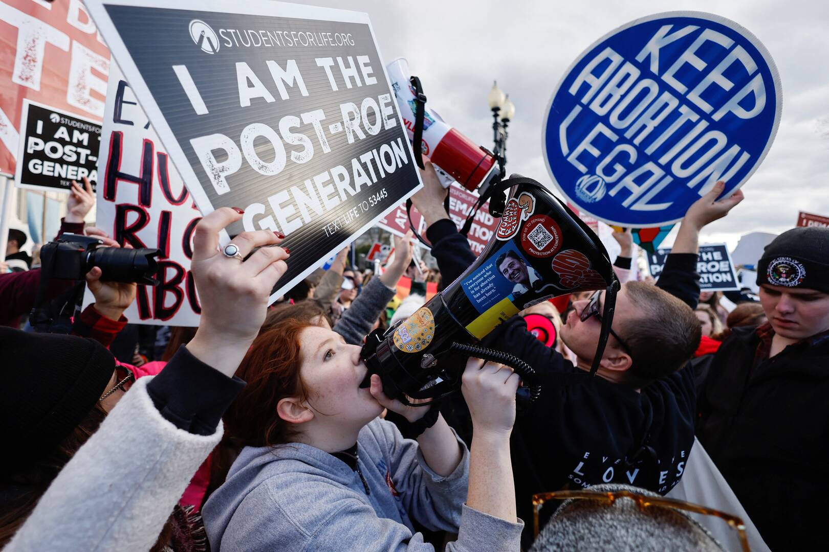 two people protesting in washington, one with a pro-life sign and one with a pro-choice sign