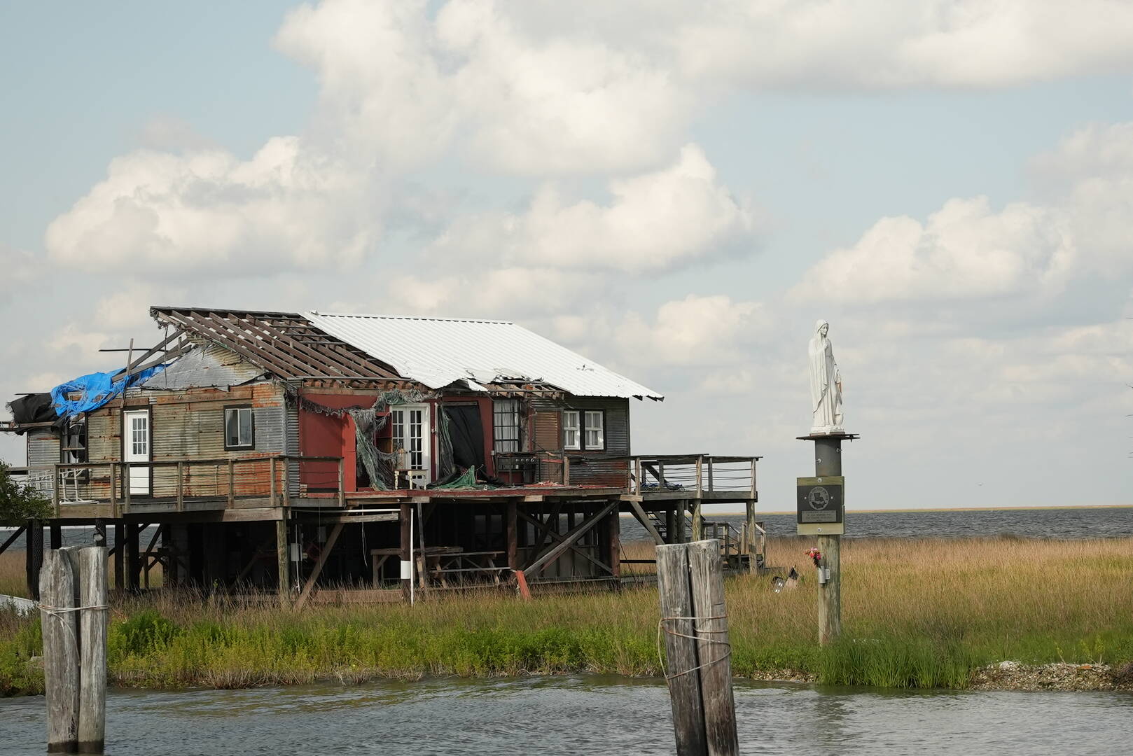 A statue of Mary stands alongside a hurricane-damaged house on the coast of southern Louisiana.