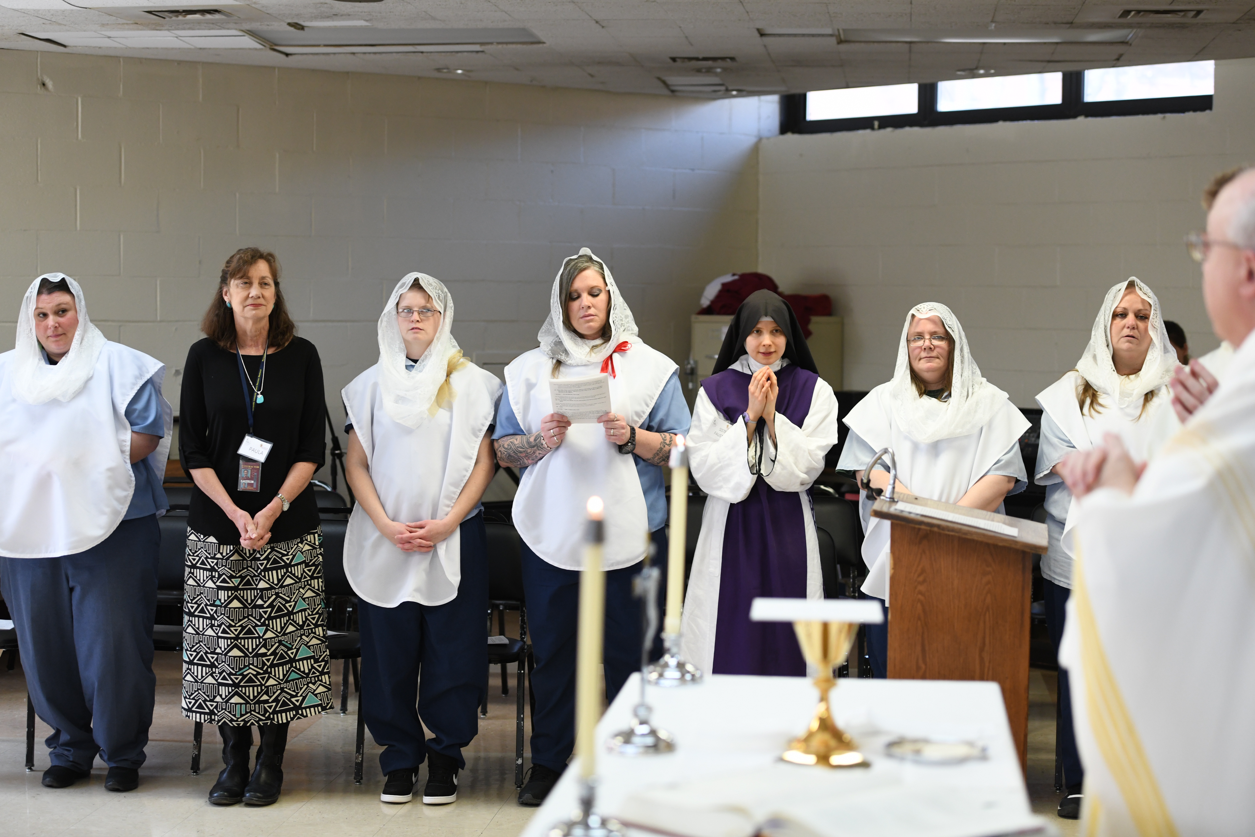 All five catechumens, a volunteer and a member of the Children of Mary stand during D.C.I.’s Catholic Easter Mass. 