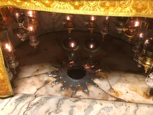The place of Christ’s birth is marked with a polished silver star on the floor of a candlelit enclave