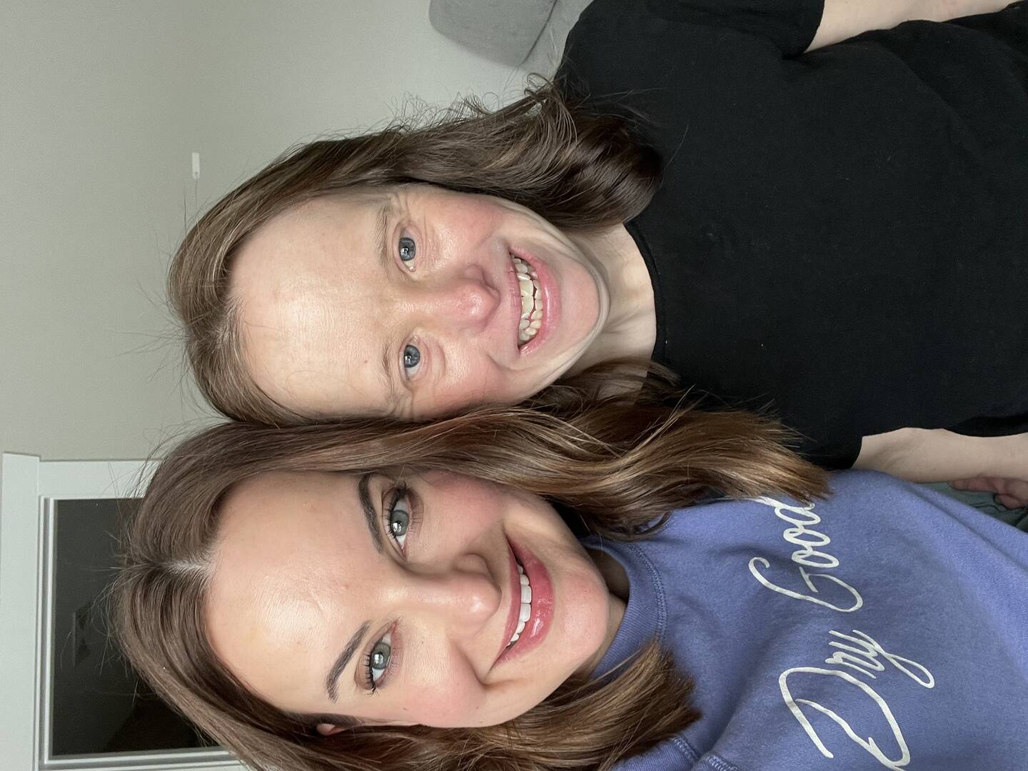 the author smiles with her sister leanne. the author's shirt says dry goods in a scripted font, and leanne is wearing black. leanne has down syndrome