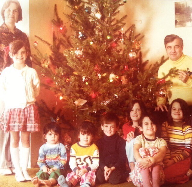 Keane family at Christmas. Mother, father and seven children around Christmas tree.