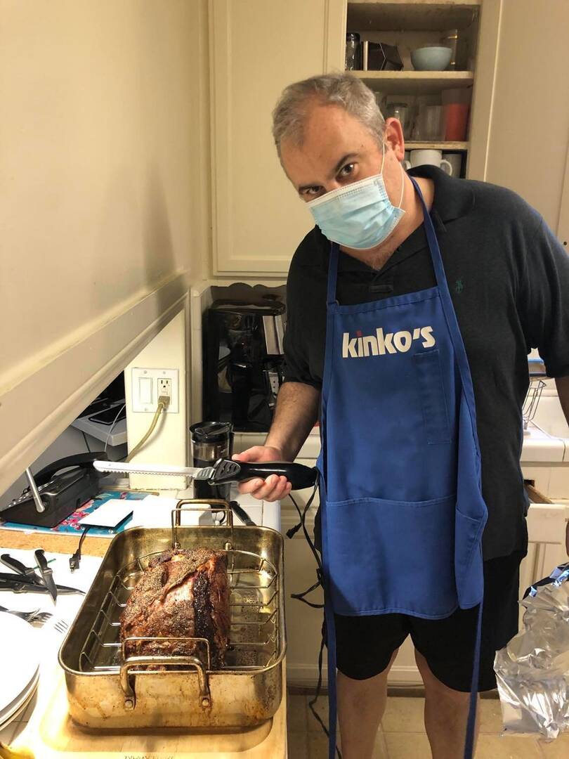 James Keane cooking, wearing a mask and apron