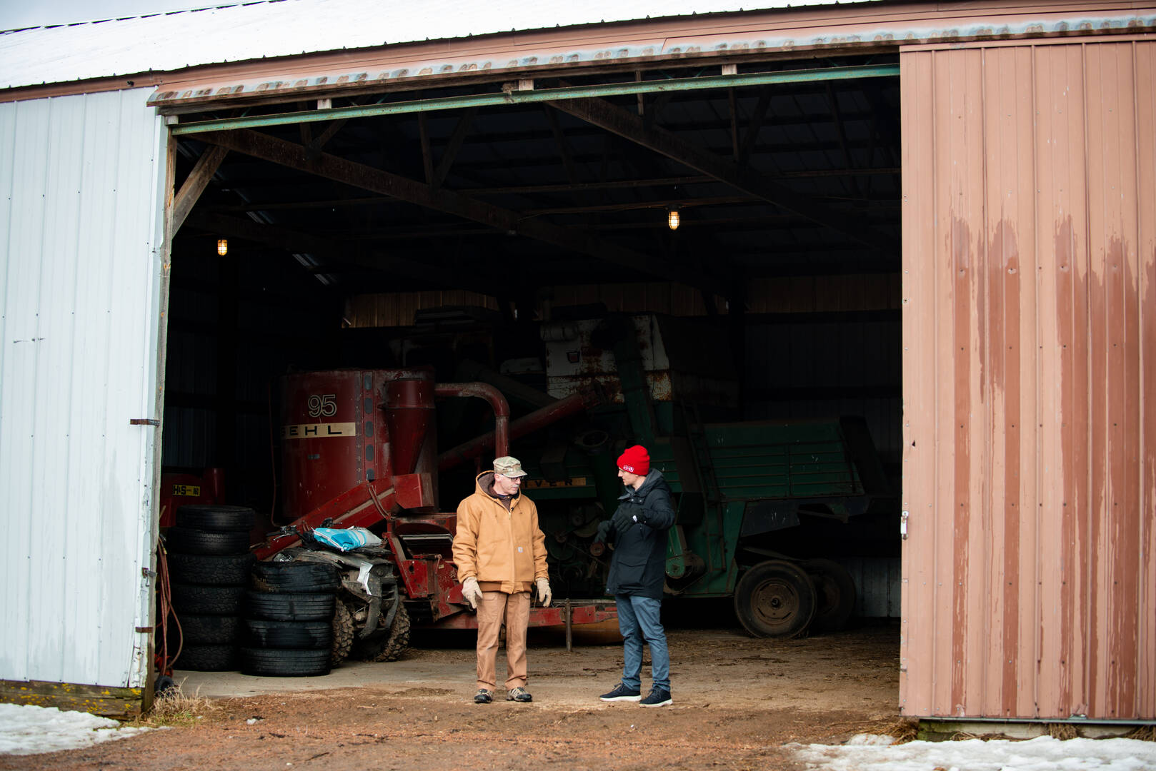 Deacon Andy Bures (left) on his family farm in Antigo, Wis. with Sebastian Gomes of America Media.
