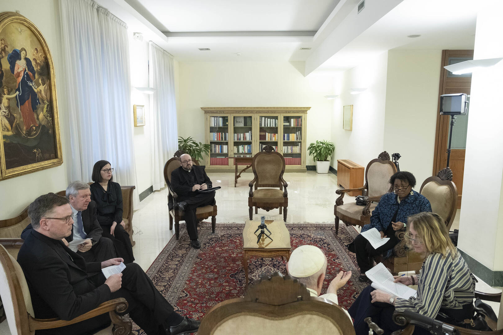 Pope Francis is seated with the editors and staff of America, seen from above