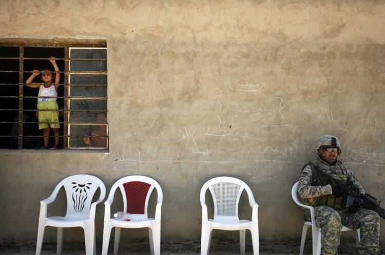 Iraqi children look out a window as local tribe leaders meet with Iraqi and U.S. security forces near Muqtadiyah in Iraq's Diyala province in 2008. (CNS photo/Damir Sagolj, Reuters) 