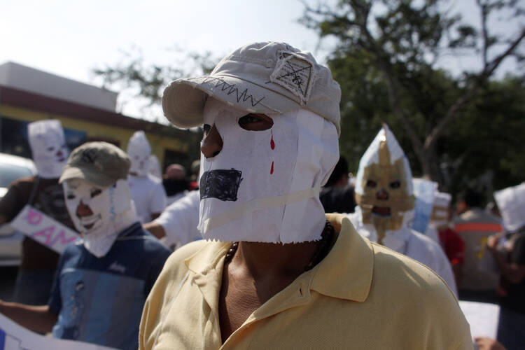 Migrants from Guatemala and El Salvador cover their faces with paper masks Aug. 28 before a silent march in Saltillo , Mexico, in honor of the 72 migrants who were killed Aug. 24, 2010, in the Mexican state of Coahuila. 