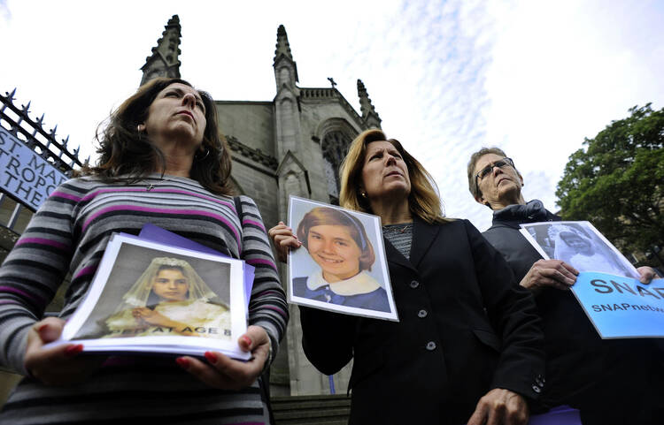 Members of the U.S.-based Survivors Network of those Abused by Priests, or SNAP hold portraits of themselves as youths as they address the media during a protest outside St. Mary's Catholic Cathedral in Edinburgh, Scotland